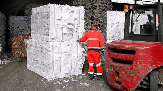 An employee works on pressed paper waste