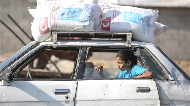 A Palestinian child sits in a car carrying aid distributed by the UNRWA and the Turkish Disaster and Emergency Management Authority (AFAD) in Gaza City, Gaza, on September 4, 2018.