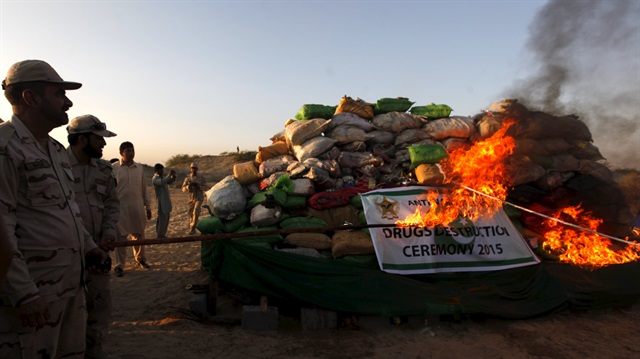 A soldier torches a pile of narcotics during a joint destruction ceremony