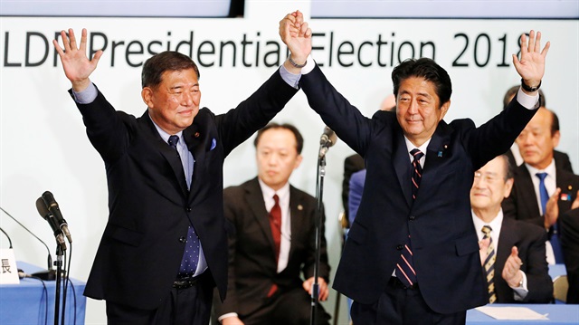 Japan's Prime Minister Shinzo Abe (R), who is also the ruling Liberal Democratic Party's (LDP) leader, raises his hands with former defence minister Shigeru Ishiba after Abe won the ruling party leadership vote at the party's headquarters in Tokyo, Japan September 20, 2018. 