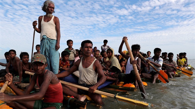 Rohingya refugees cross the Naf River with an improvised raft