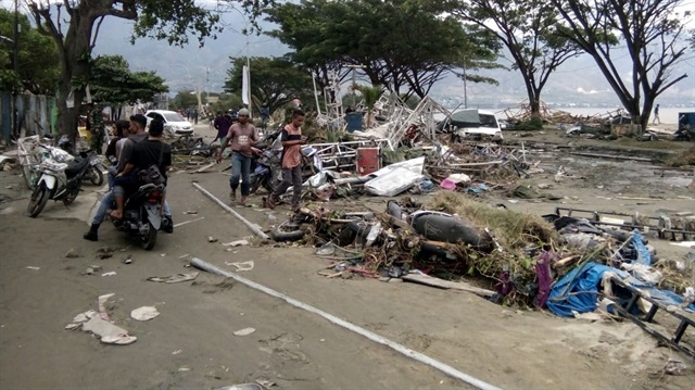 Resident checks dead bodies to find their family at a street after tsunami hit in Palu, Indonesia September 29, 2018. 