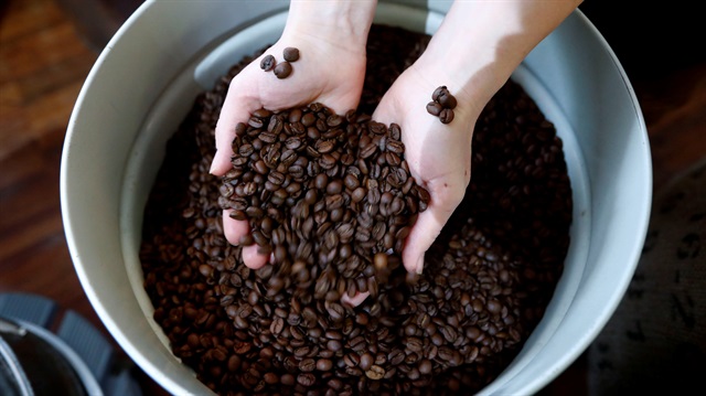  A staff member poses with roasted coffee beans 