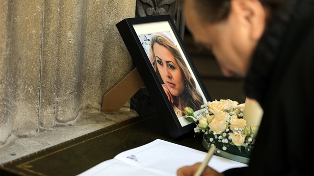 A man writes in the condolence book next to the picture of killed Bulgarian journalist Viktoria Marinova before her funeral service in Holy Trinity Cathedral in Ruse, Bulgaria, October 12, 2018. 