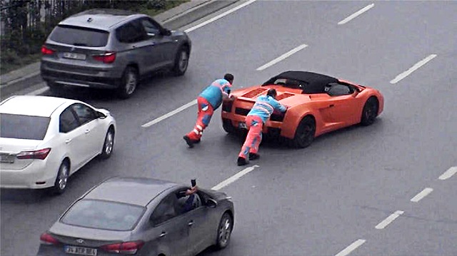 Lamborghini'yi iterek götüren işçiler vatandaşların cep telefonuna takıldı.