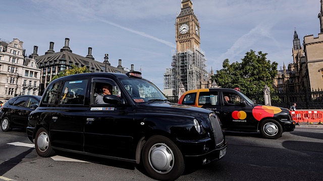 File photo: Black taxis pass the Houses of Parliament in London, Britain