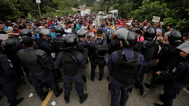 Honduras polis yetkilileri göçmenleri çıkarmamak için sınırda nöbet tutuyor. 
