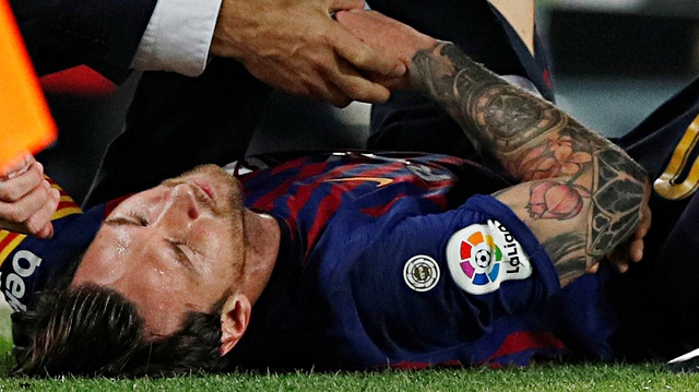 Barcelona's Lionel Messi receives medical attention after sustaining an injury 