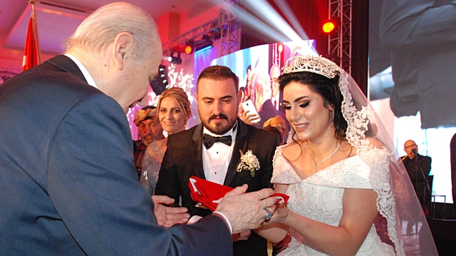 Nikah şahidi olan MHP Lideri Bahçeli, genç çifte Türk bayrağı hediye etti.