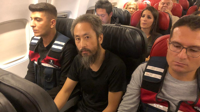 Japanese journalist Jumpei Yasuda sits between Turkish gendarmes on a Istanbul-bound flight due for departure at Hatay airport, Turkey October 24, 2018. 