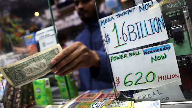 A newsstand vendor takes a customer's cash for tickets in Tuesday's Mega Millions and Wednesday's Powerball lottery drawings in New York City, New York, U.S., October 23, 2018. 