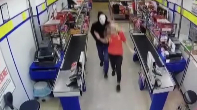 Yüzüne maske takan zanlı, market çalışanını silah zoruyla kasaya götürdüğü görülüyor. 