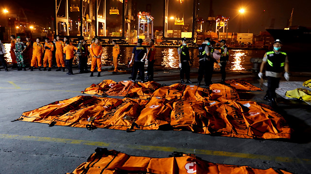 An Indonesian Disaster Victim Identification (DVI) officer walks near body bags from passengers of Lion Air flight JT610 at Tanjung Priok port in Jakarta, Indonesia, November 4, 2018.  