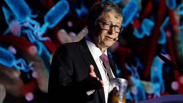 Microsoft founder Bill Gates points at a jar containing human faeces during his speech at the Reinvented Toilet Expo showcasing sewerless sanitation technology in Beijing, China November 6, 2018. 