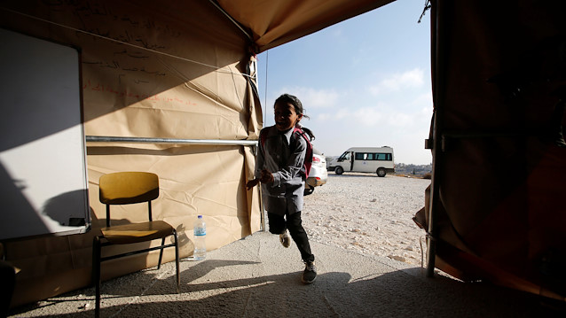 File photo: A Palestinian schoolgirl arrives to attend lessons inside a tent 