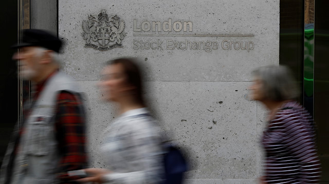 People walk past the entrance of the London Stock Exchange in London, Britain.