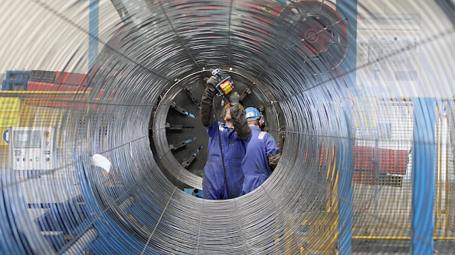 A worker is seen through a pipe at French pipe coating company EUPEC in Sassnitz May 6, 2011. EUPEC is working to complete around 200,000 pipes for Nord Stream. 