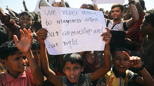 A boy holds a placard as hundreds of Rohingya refugees protest against their repatriation 