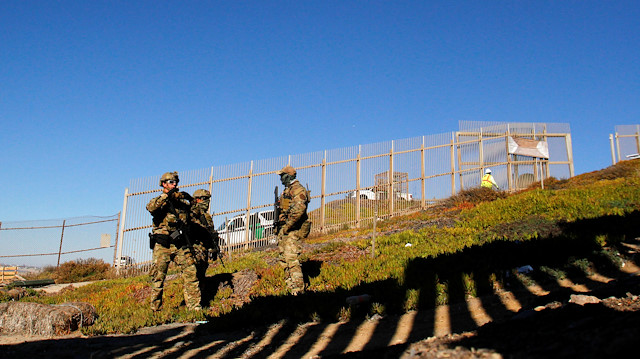 Agents with the U.S. Border Patrol Tactical Unit (BORTAC) stand guard behind the border fence between Mexico and the United States, as seen from Tijuana, Mexico November 14, 2018. 