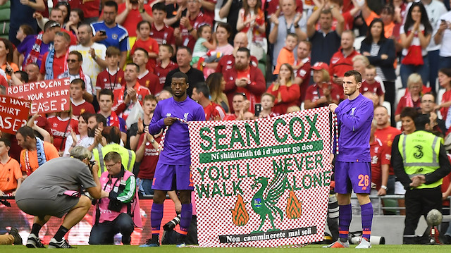 Liverpool's Georginio Wijnaldum and Andrew Robertson hold up a banner in support of Liverpool fan Sean Cox after the match 