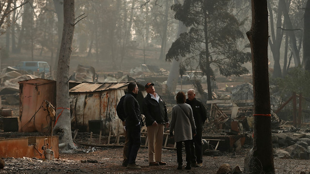 U.S. President Donald Trump visits the Skyway Villa Mobile Home and RV Park, a neighborhood recently destroyed by the Camp Fire, with Governors of California Jerry Brown, right, Mayor Jody Jones, second from right, Brock Long, back left, and Governor-elect Gavin Newsom in Paradise, California, U.S., November 17, 2018. 