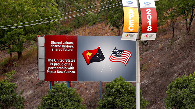 A man walks past a billboard displaying the national flags of the United States and Papua New Guinea a day after the Asia Pacific Economic Cooperation (APEC) forum ended, in Port Moresby, Papua New Guinea.