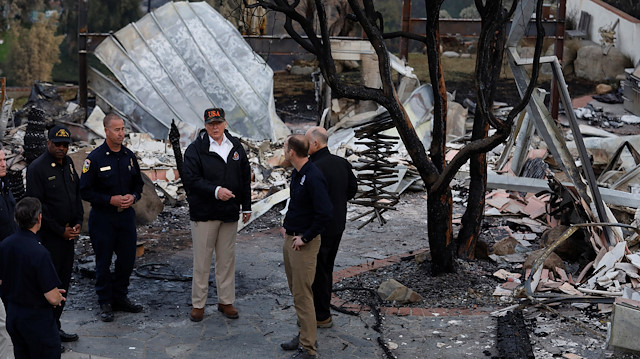 U.S. President Donald Trump (C) surveys homes destroyed by the Woolsey fire with first responders in Malibu, California, U.S., November 17, 2018. 
