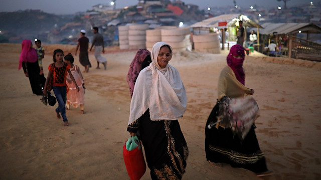 Rohingya refugees walk along the road in the evening at Balukhali camp in Cox’s Bazar, Bangladesh