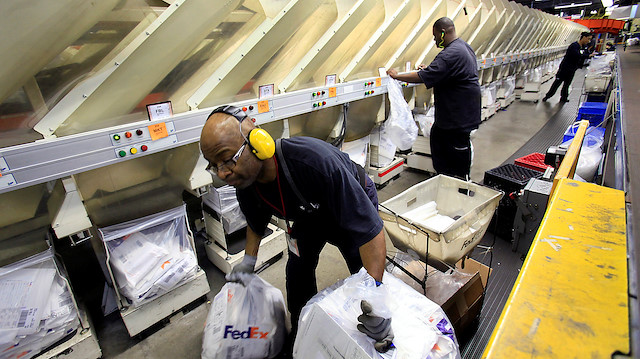 FedEx employees Adrian Steele (L) and Aurra Wilks help sort packages in the company's small package sorting system at the Memphis World Hub in Memphis, Tennessee, US.
