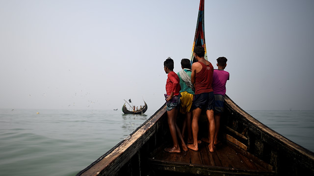 Rohingya refugees crew a fishing boat in the Bay of Bengal near Cox's Bazaar, Bangladesh