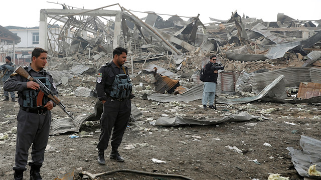 Afghan policemen stand guard at the site of a car bomb attack in Kabul, Afghanistan,