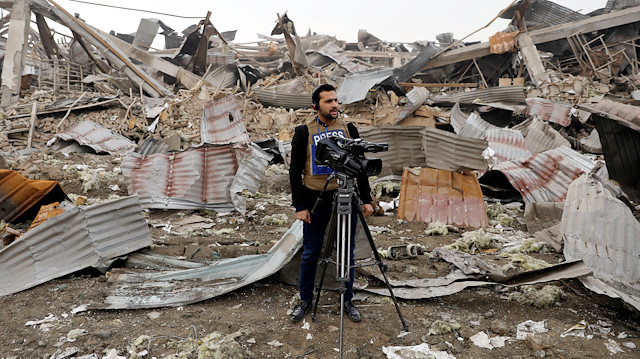 A journalist films the site of a car bomb attack in Kabul, Afghanistan