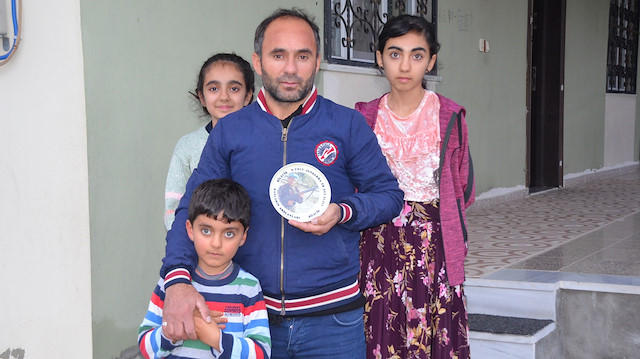 2000 yılında askerliğini yapan Tokuş, çocukları ve askerlik hatırası porselenle poz verdi.