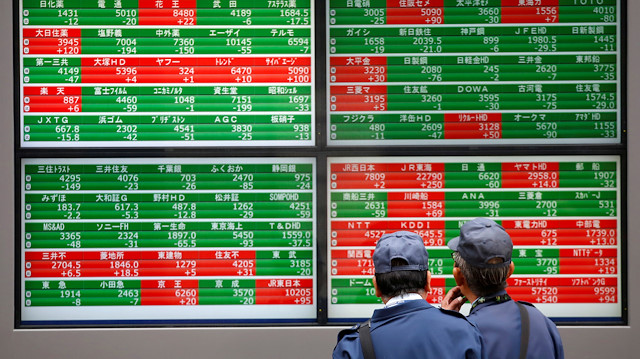 Men look at stock quotation boards outside a brokerage in Tokyo, Japan.