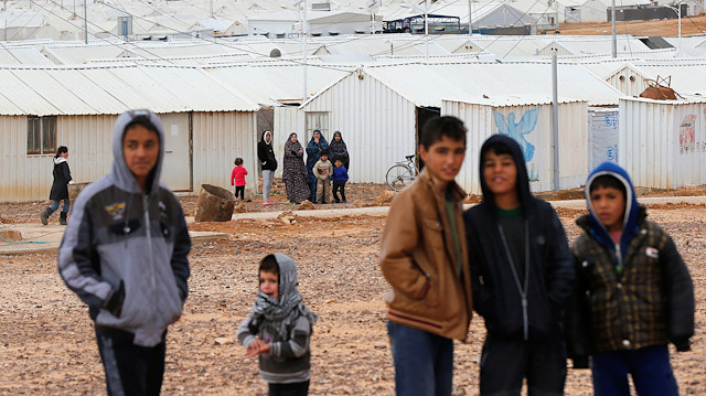 Syrian refugees look at the camera as they stand in front of their homes at Azraq refugee camp, near Al Azraq city, Jordan, December 8, 2018. 