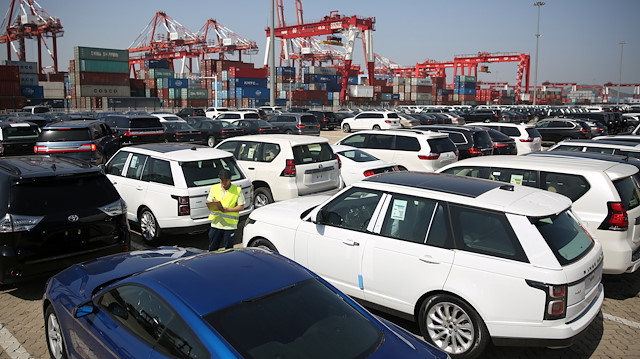 A worker inspects imported cars at a port in Qingdao, Shandong province, China.
