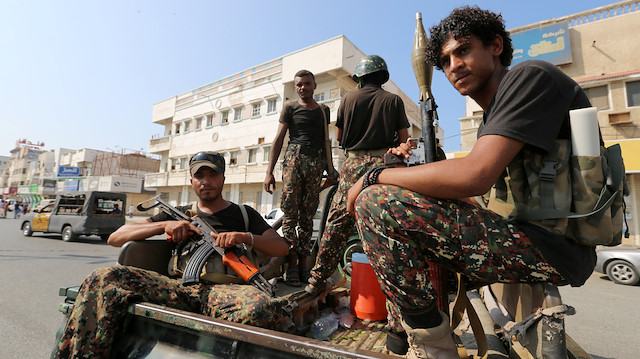 Houthi militants patrol a street where pro-Houthi protesters 