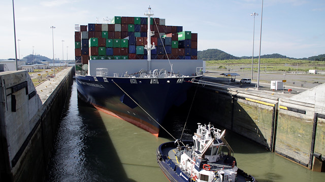 A tugboat drags the British CMA CGM T. Roosevelt cargo vessel