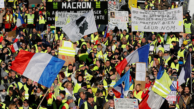 Protesters wearing yellow vests wave French flags and carry banners as they take part in a demonstration of the "yellow vests" movement in Marseille, France, December 15, 2018