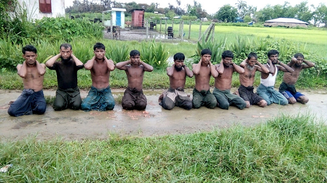 Ten Rohingya Muslim men with their hands bound kneel in Inn Din village, Myanmar