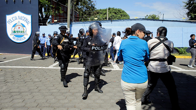 Riot police dislodges journalists from the main entrance of police headquarters in Managua, Nicaragua.