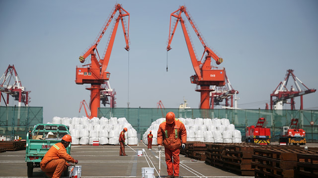 Workers paint the ground at a port in Qingdao, Shandong province, China.