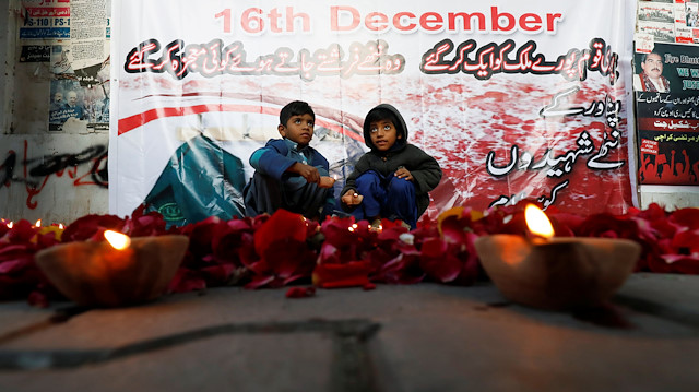 Children hold oil lamps after they light with others to remember the victims of an attack on the Army 