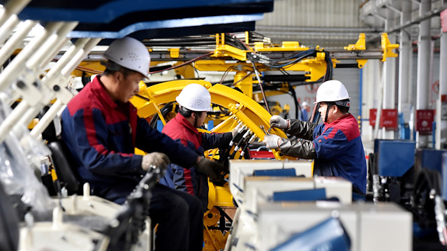 Employees work on a drilling machine production line at a factory in Zhangjiakou, Hebei province, China.
