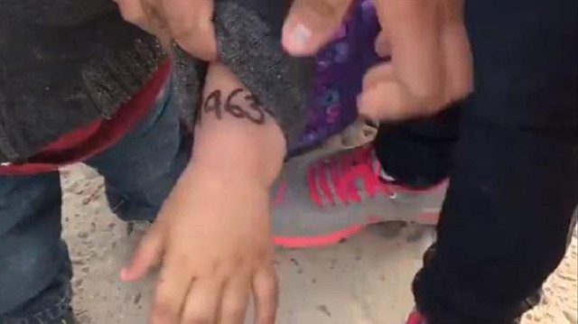 Migrant children marked with numbers 