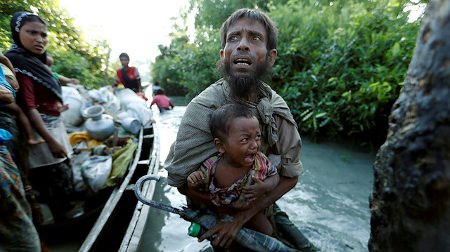 Rohingya refugees arrive to the Bangladeshi side of the Naf River after crossing the border from Myanmar.