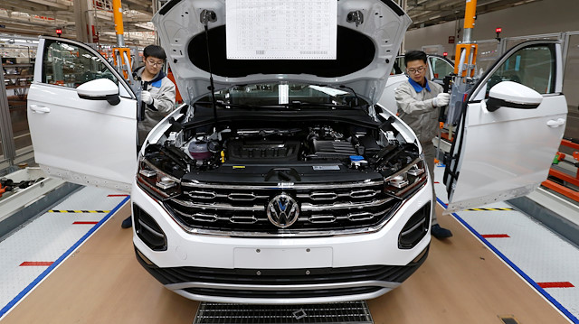Workers are seen at the production line for Volkswagen Tayron cars