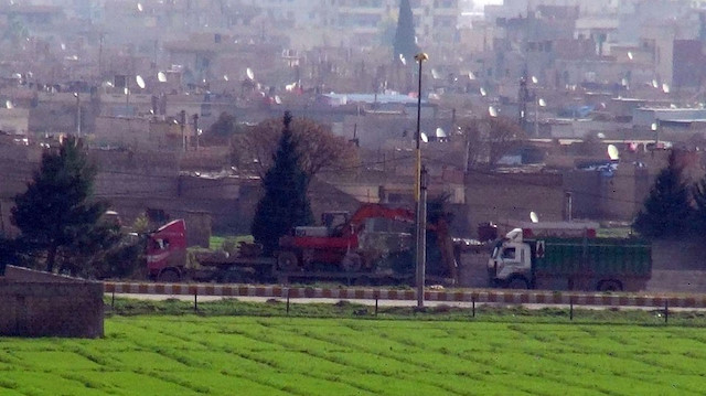 YPG/PKK'lılar çukur kazmak için tırlarla iş makinesi taşıyor.