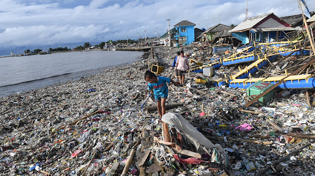 Residents walk among debris after the tsunami at Labuan in Pandeglang, Banten province