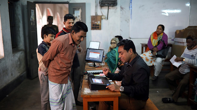 A presiding officer helps a man to cast his vote on an Electronic Voting Machine (EVM) during a day long mock voting test ahead of the 11th general election in Dhaka, Bangladesh, December 27, 2018. REUTERS/Mohammad Ponir Hossain

